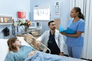Man in White Scrub Suit Massaging Man in Blue Scrub Suit