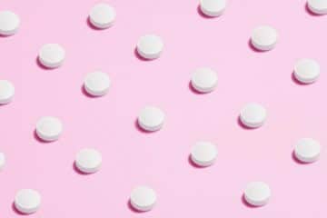 White Round Capsule On Pink Background Close-Up Photography