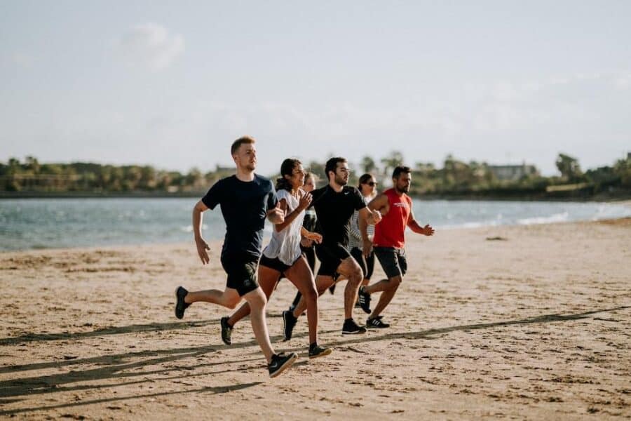 Hombres Y Mujeres Corriendo En La Orilla Del Mar
